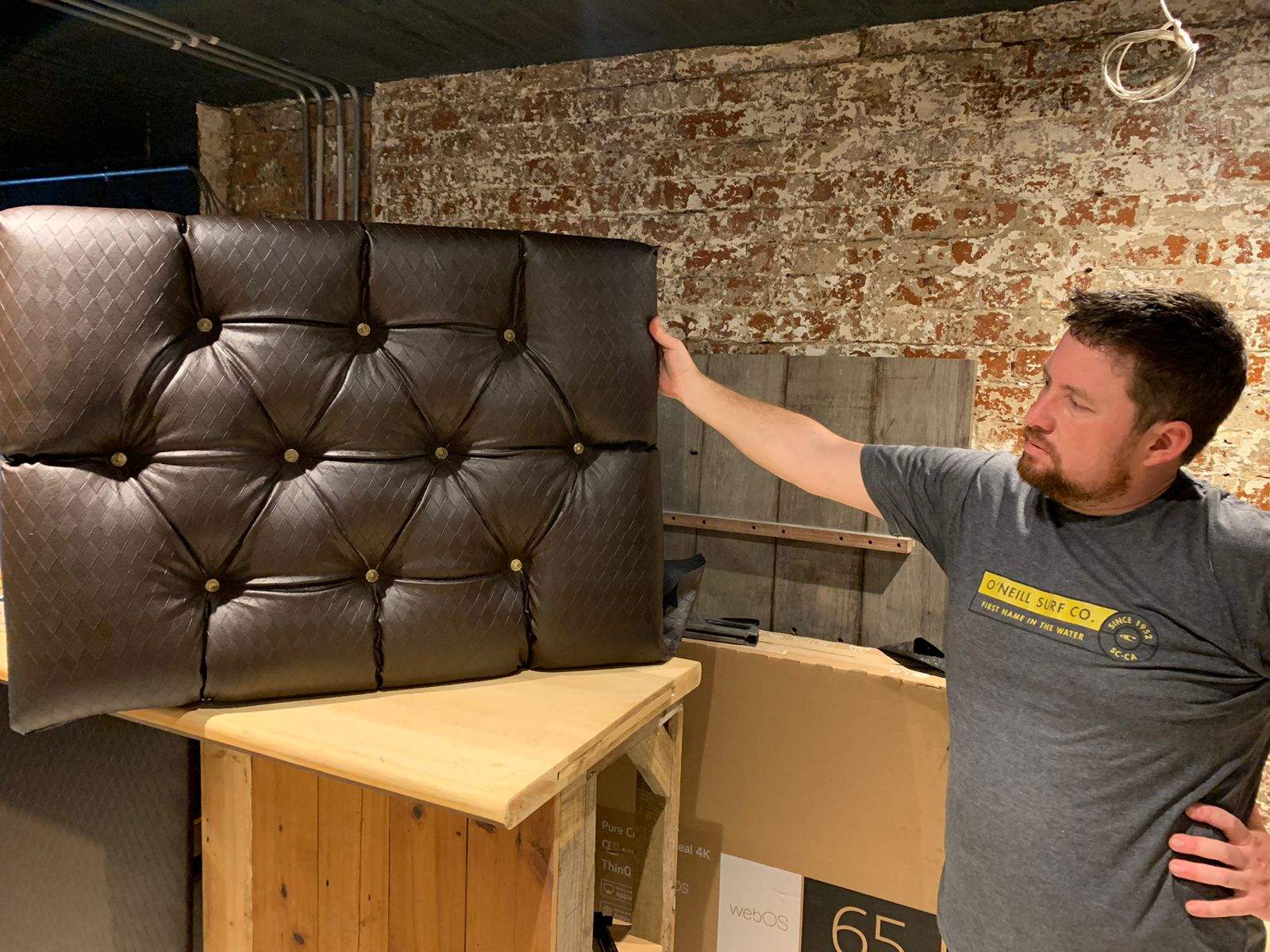 David Morel checking the custom diamond-pattern couch upholstery in the DG Technologies showroom build